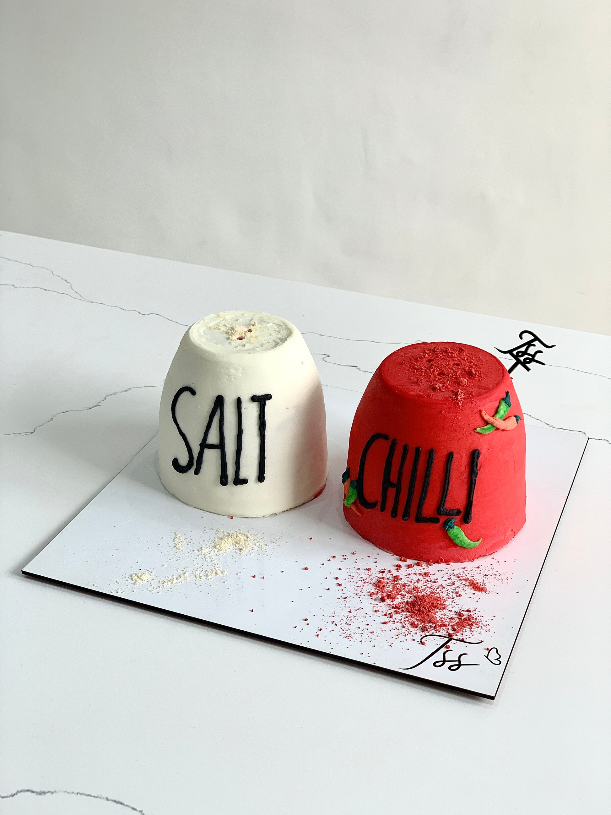 Decorative shape cakes from The Sinful Spoon featuring colorful, intricate designs on a cake display.