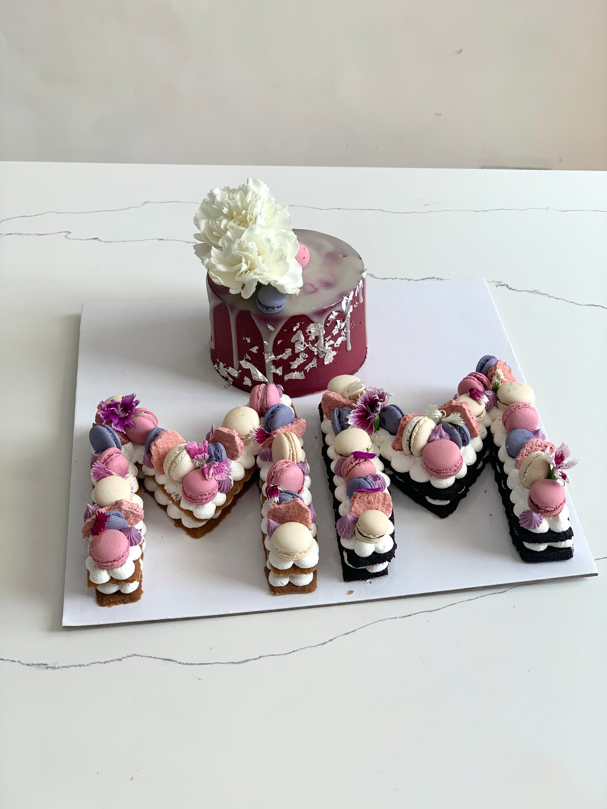 Assorted combo cakes from The Sinful Spoon with colorful frosting and decorative toppings on a white plate.