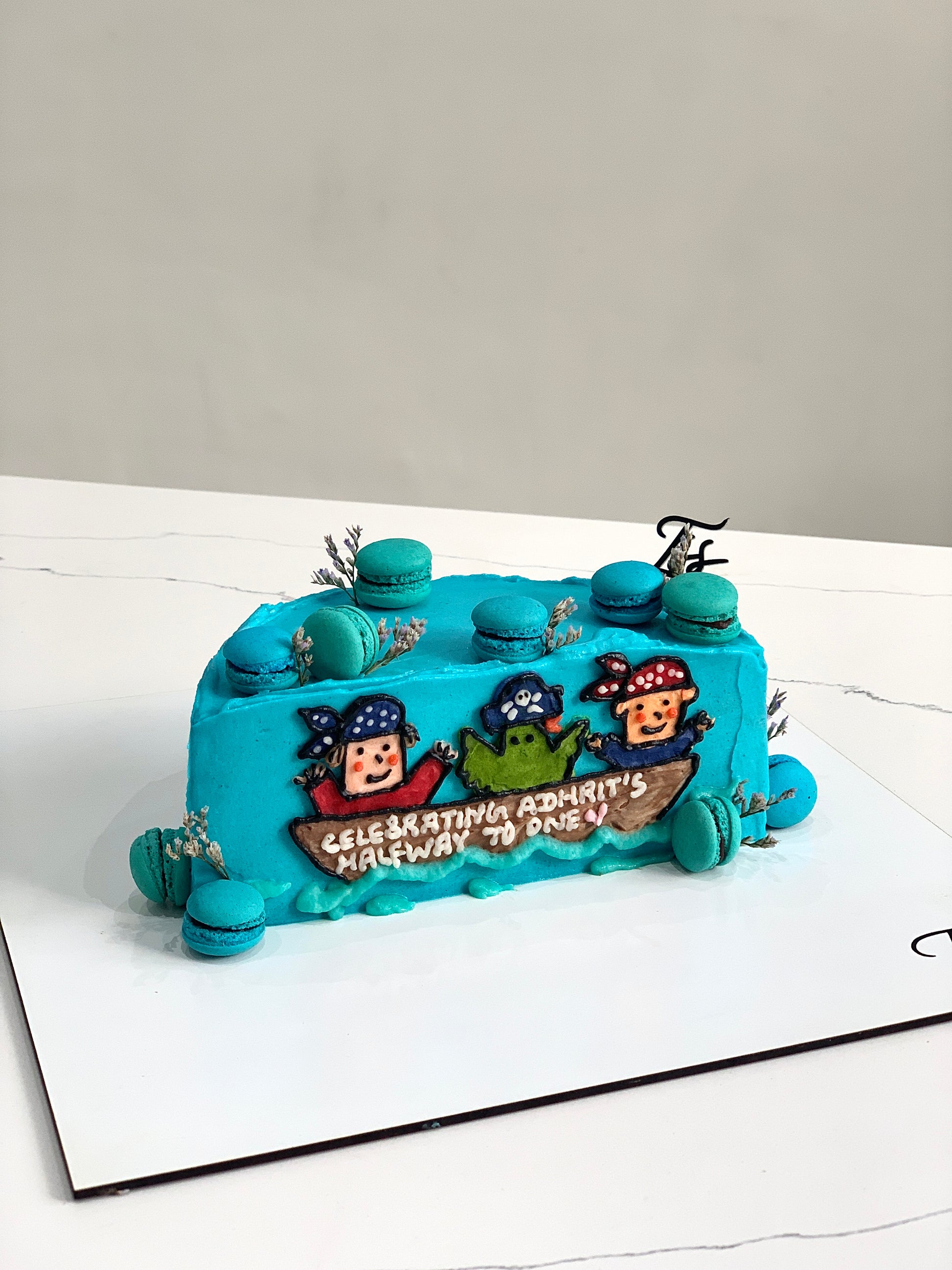 Half birthday cake from The Sinful Spoon, decorated with colorful frosting and sprinkles, perfect for celebrating special milestones.