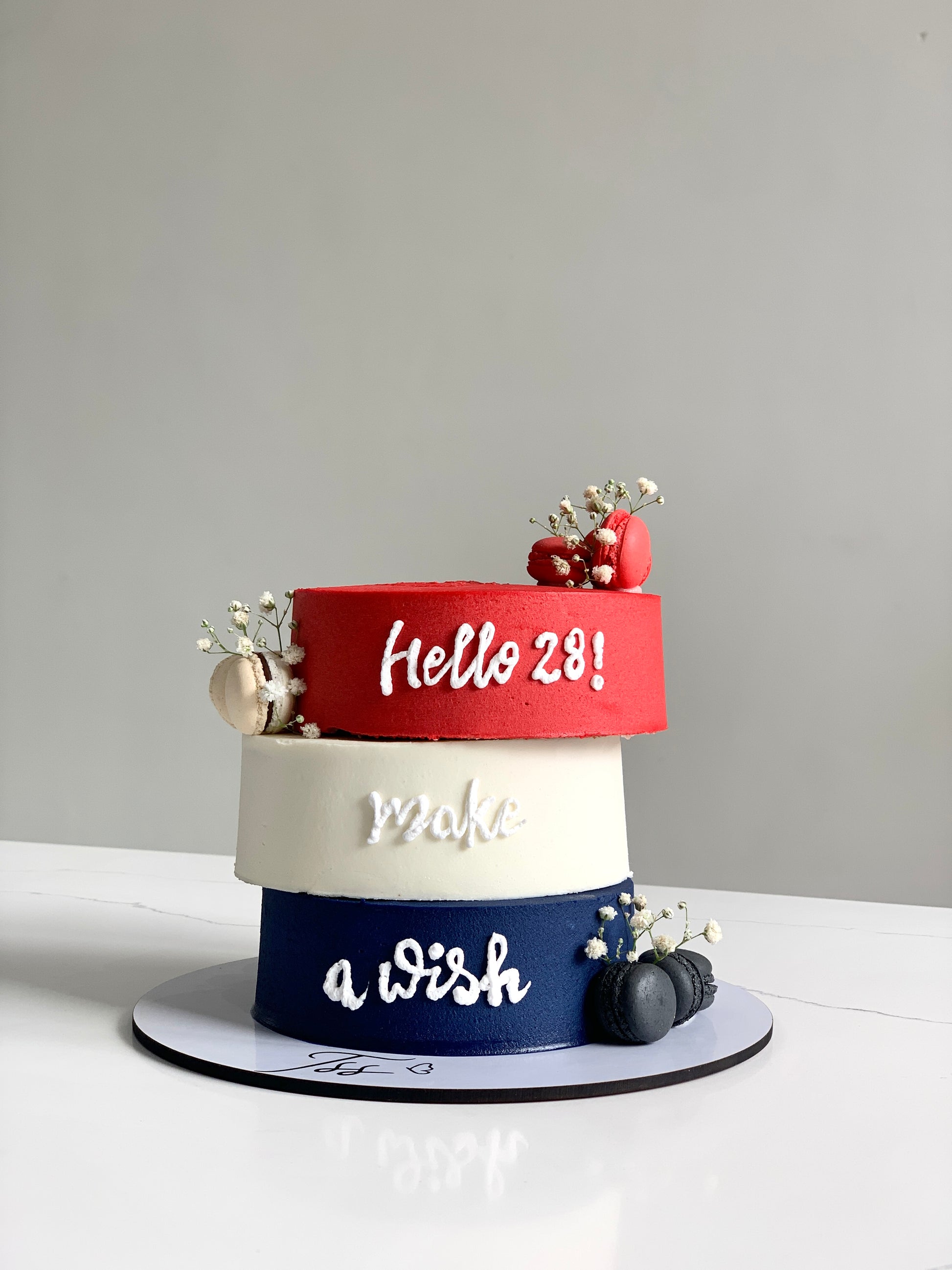 Asymmetrical cakes with layered frosting and decorative toppings from The Sinful Spoon, showcasing creative dessert designs.