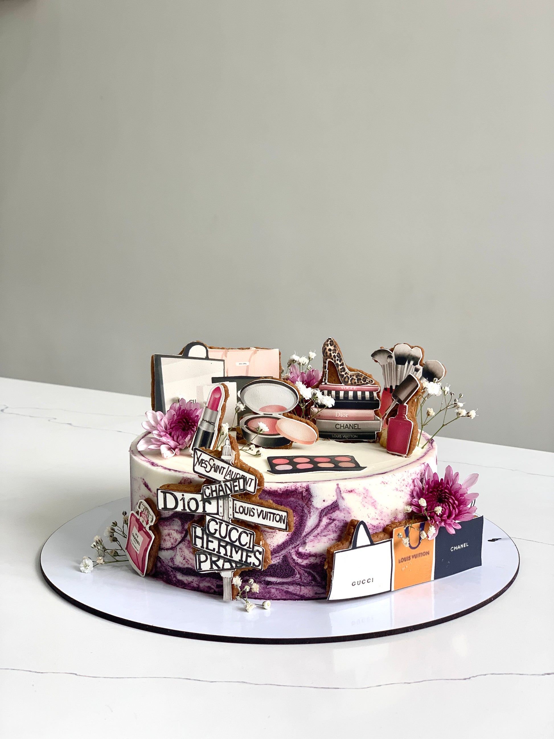 Edible paper cakes by The Sinful Spoon, decorated with colorful frosting and edible designs on a white background.