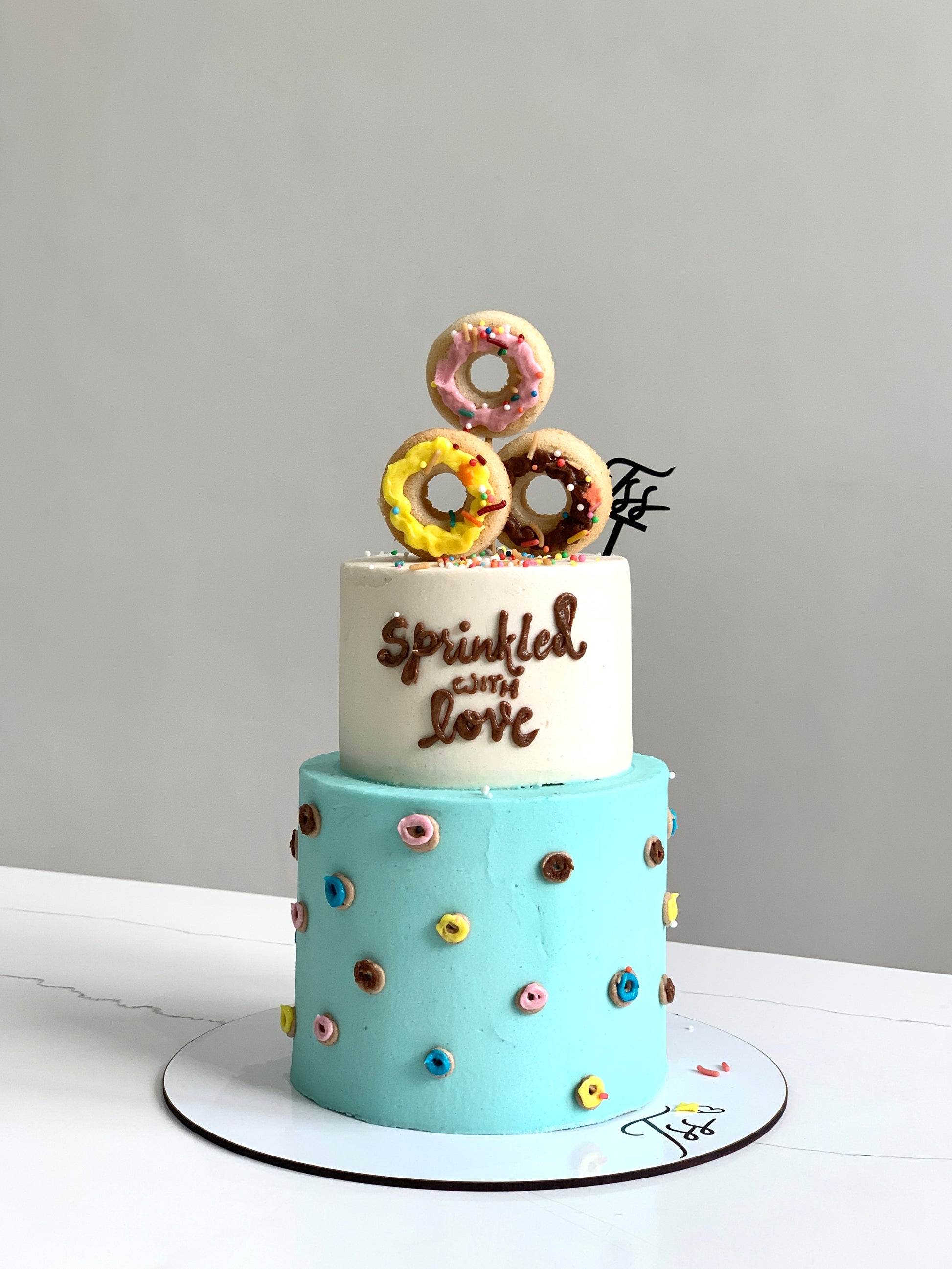 Miniature tier cakes from The Sinful Spoon, showcasing colorful, layered desserts with intricate frosting details.
