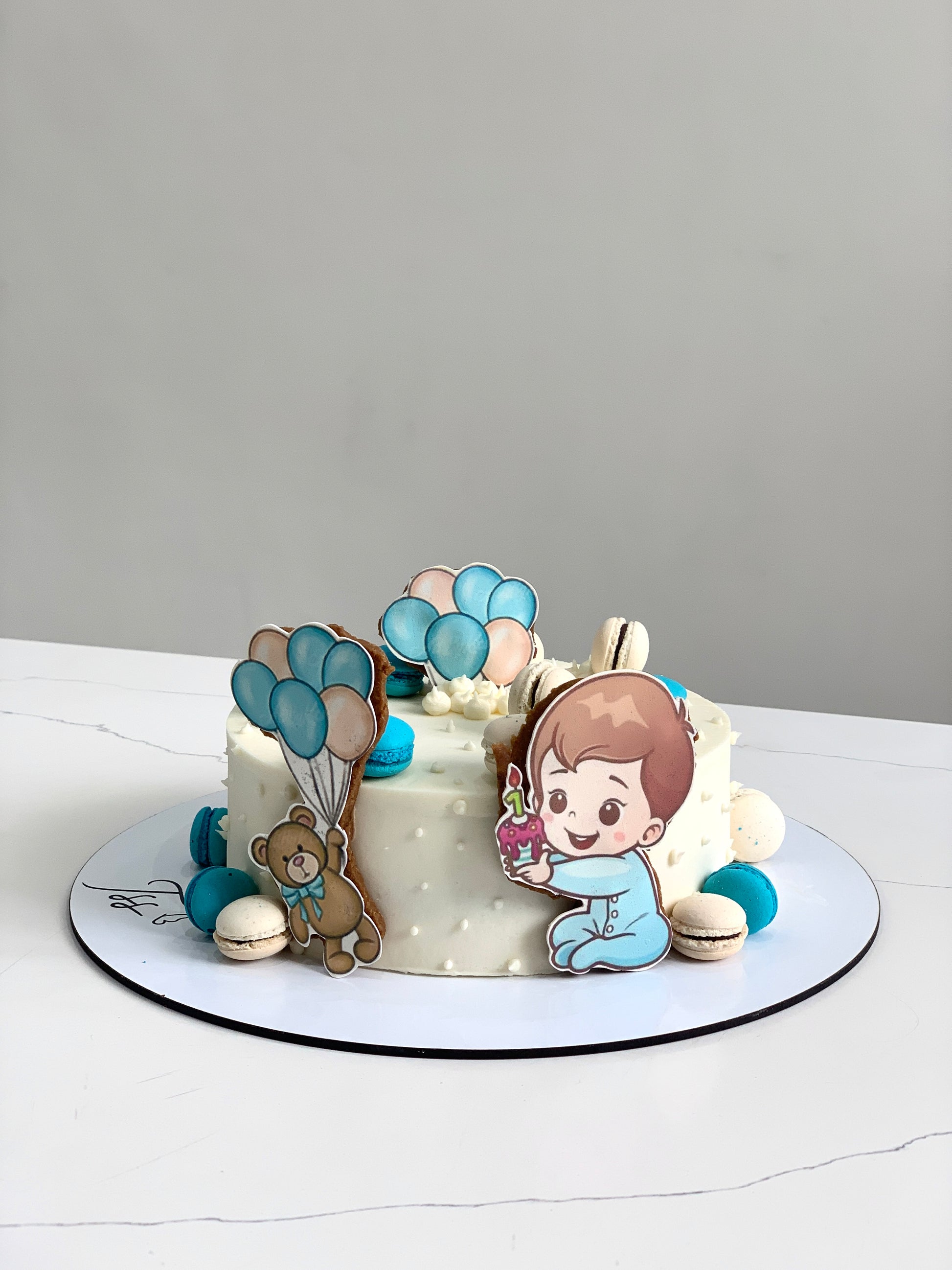 Decorative baby shower cake from The Sinful Spoon with pastel colors and cute baby-themed decorations.