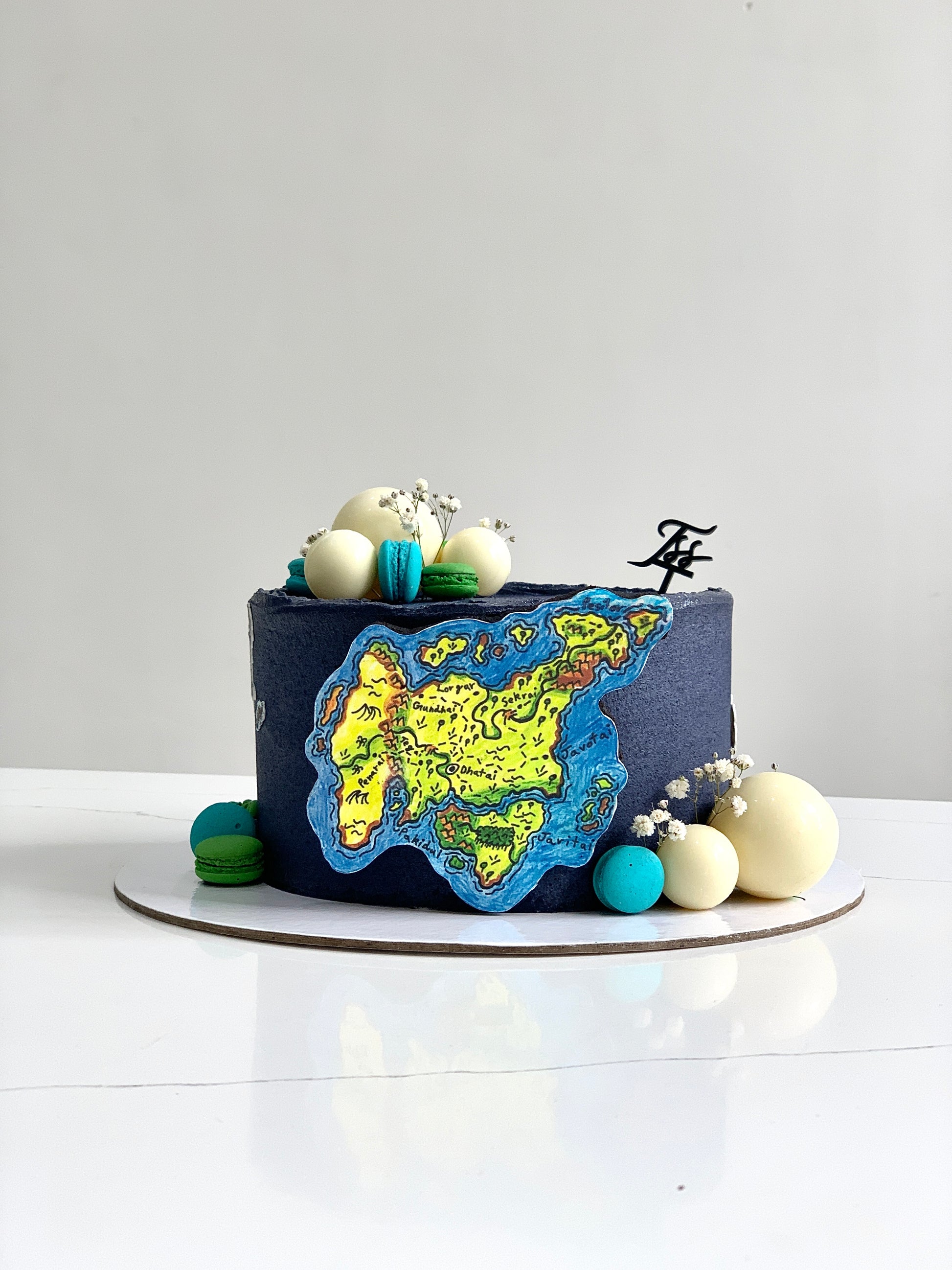 Edible paper cakes from The Sinful Spoon, decorated with colorful icing and floral designs on a white background.