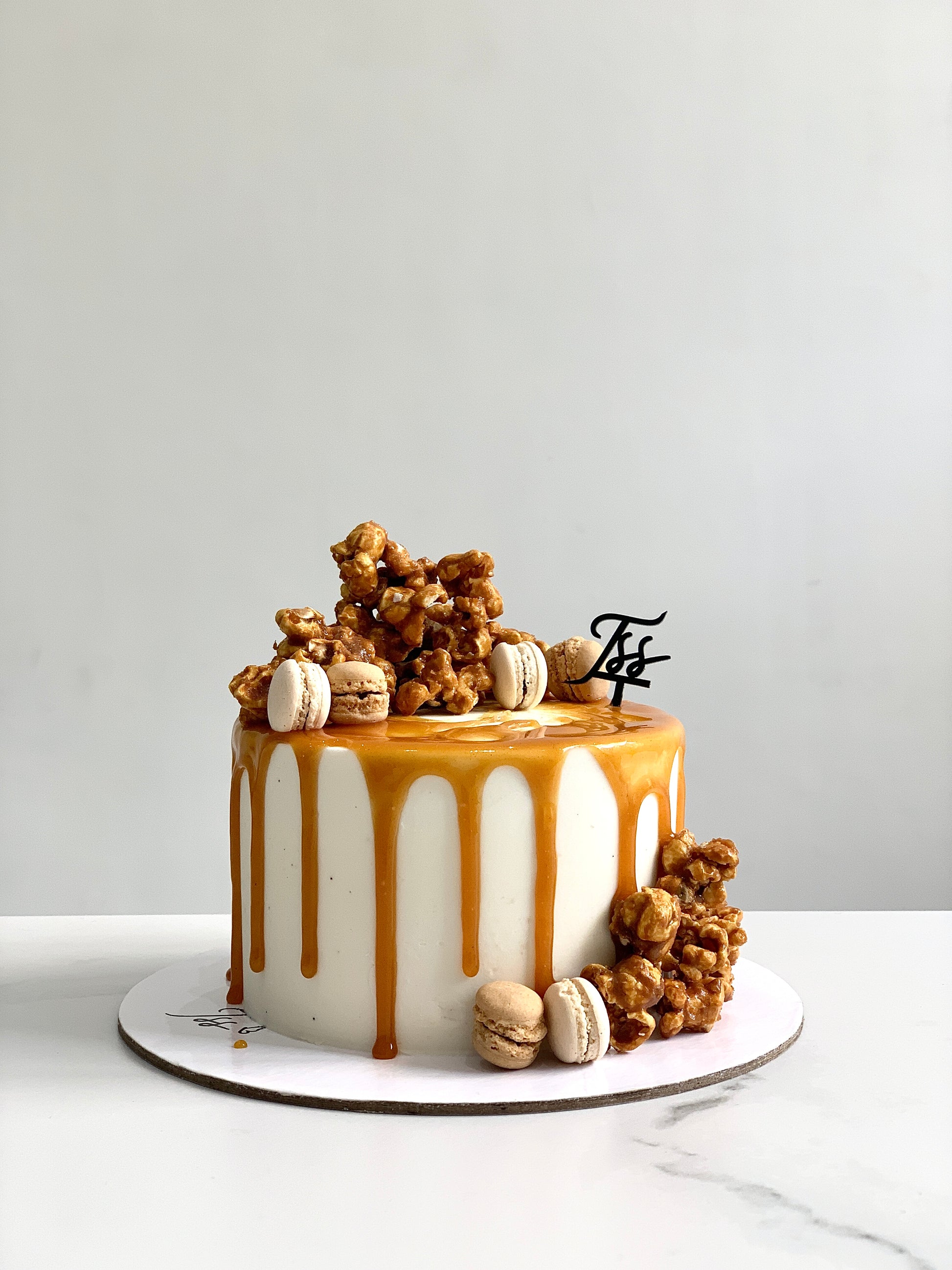 A classic cake from The Sinful Spoon featuring layered frosting and decorative toppings on a white plate.