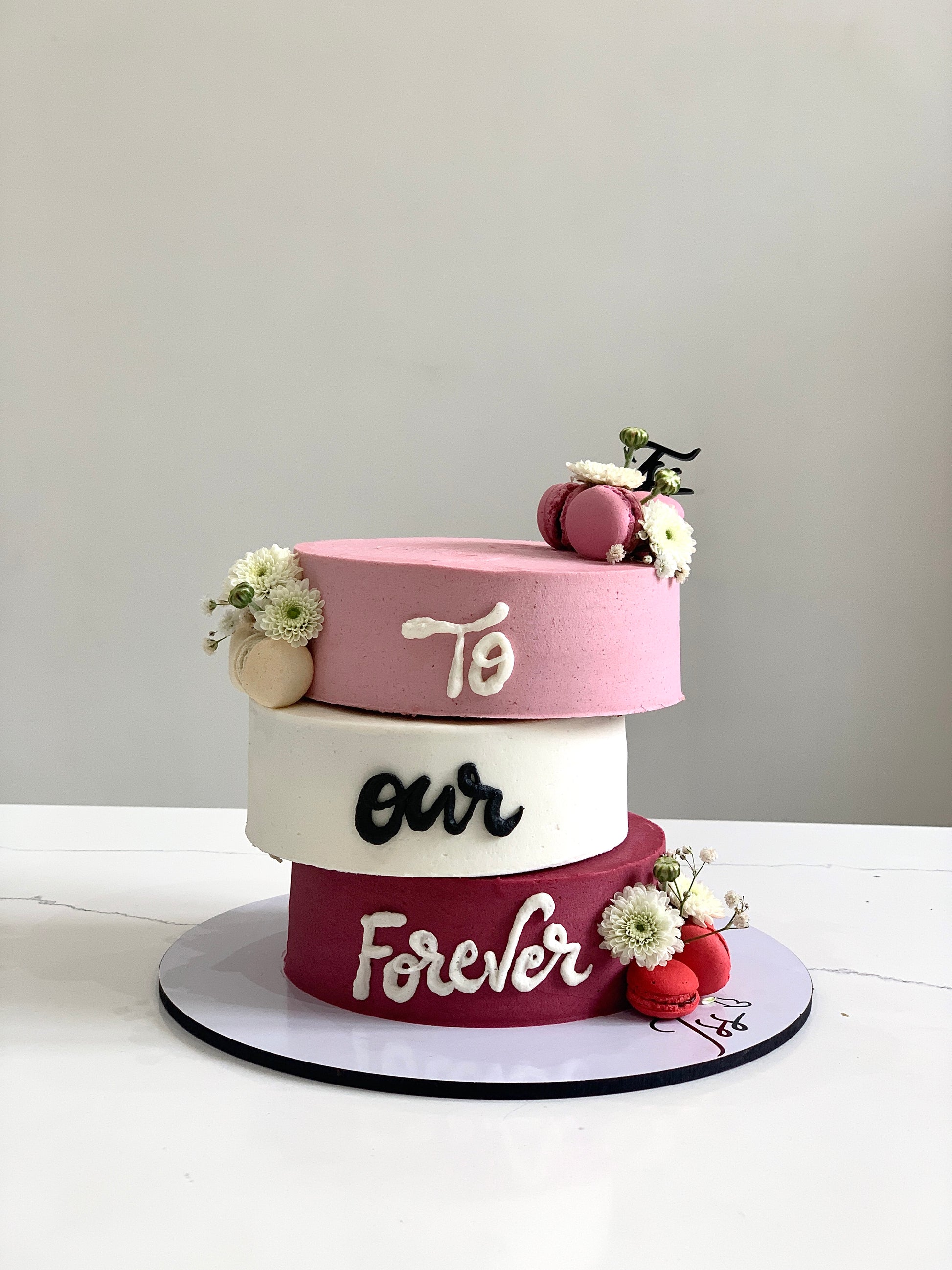 Valentine's Day cake from The Sinful Spoon featuring pink frosting, heart-shaped decorations, and romantic themed design.