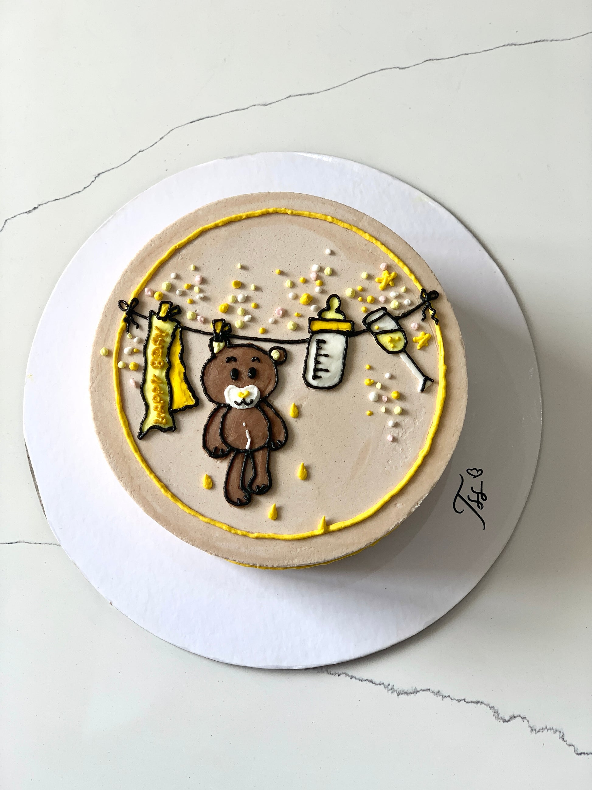 Decorative baby shower cake with pastel frosting and baby-themed toppers from The Sinful Spoon.