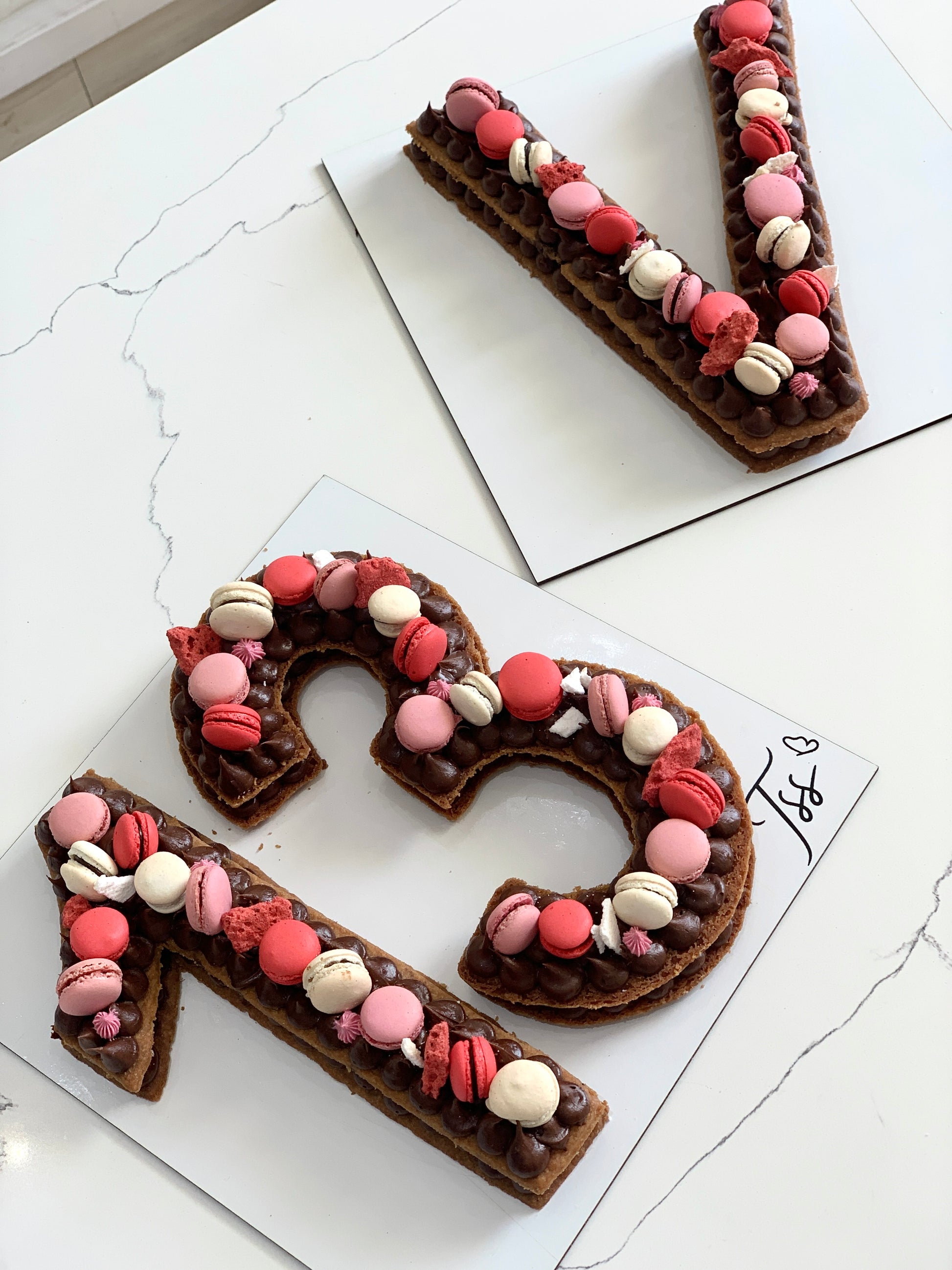 Chocolate chip cookie cake from The Sinful Spoon, topped with colorful sprinkles and decorated with pink frosting.