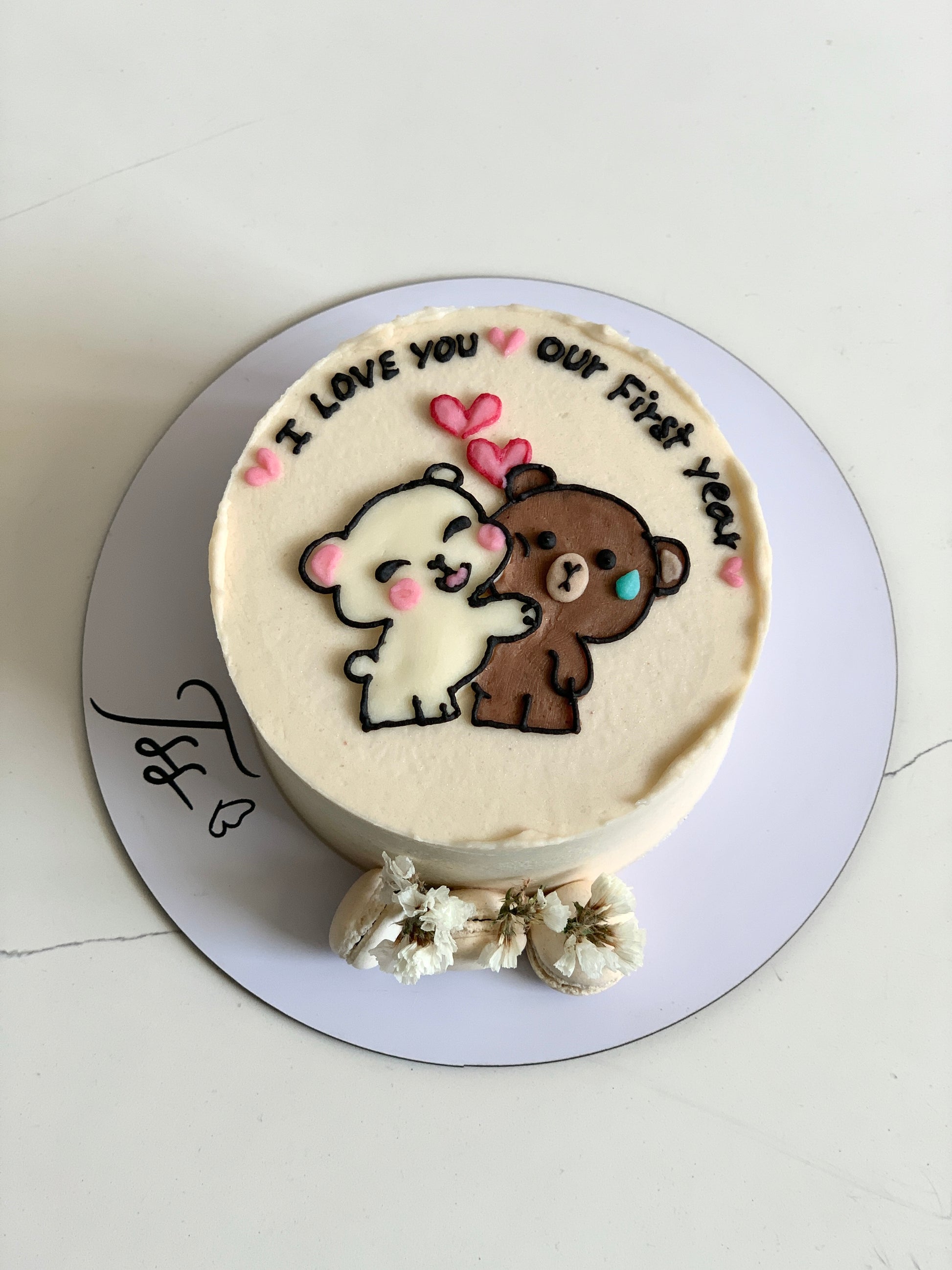 Decorative buttercream illustration cake from The Sinful Spoon featuring colorful floral and whimsical designs on a round cake.
