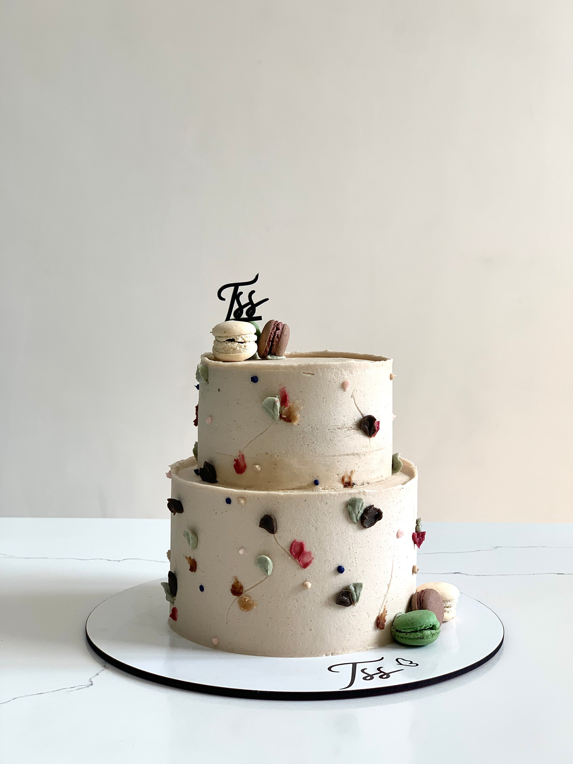 Miniature tier cakes from The Sinful Spoon with colorful frosting and decorative toppings, perfect for celebrations.