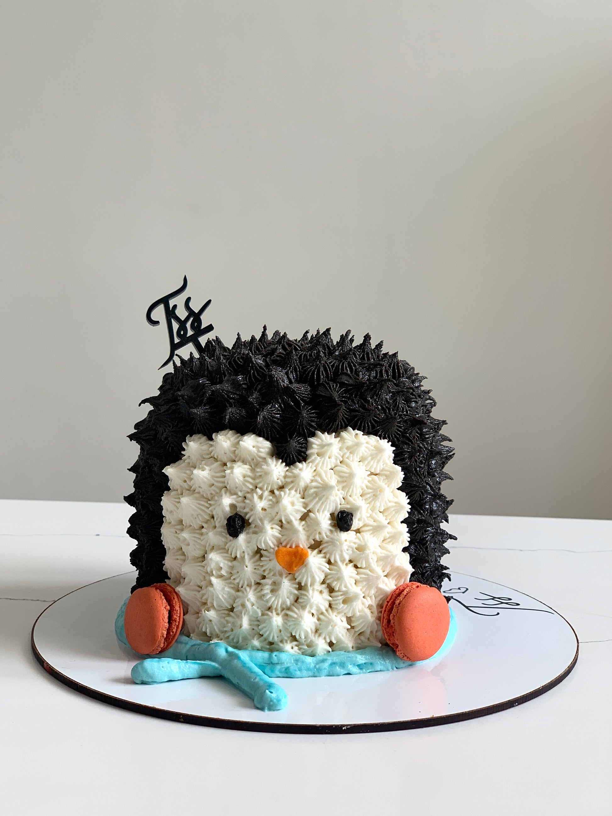 Decorative Christmas cake from The Sinful Spoon with festive icing and holiday-themed toppings on a white plate.