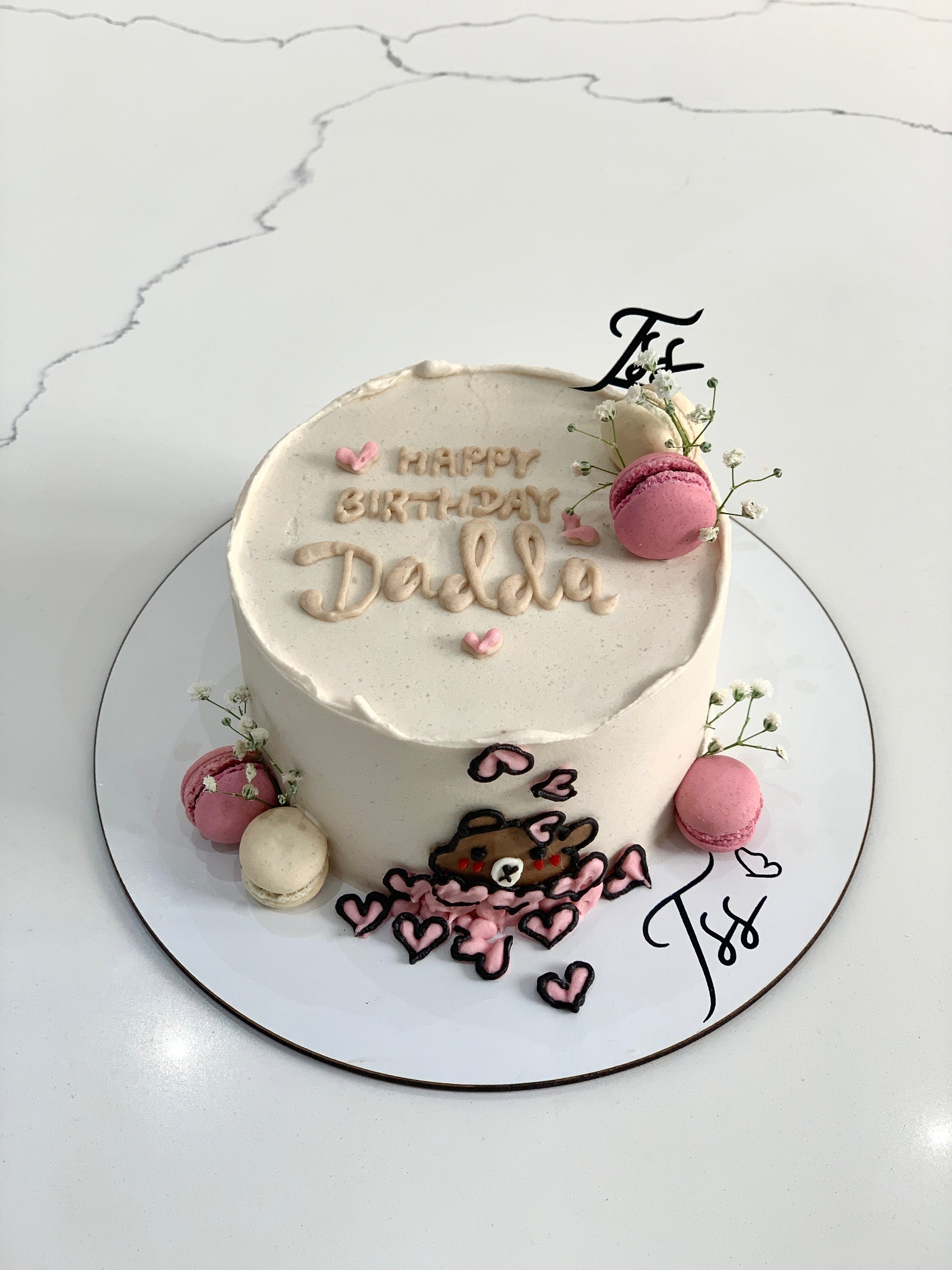 Valentine's Day cake from The Sinful Spoon with pink and red frosting, heart-shaped decorations, and festive design.