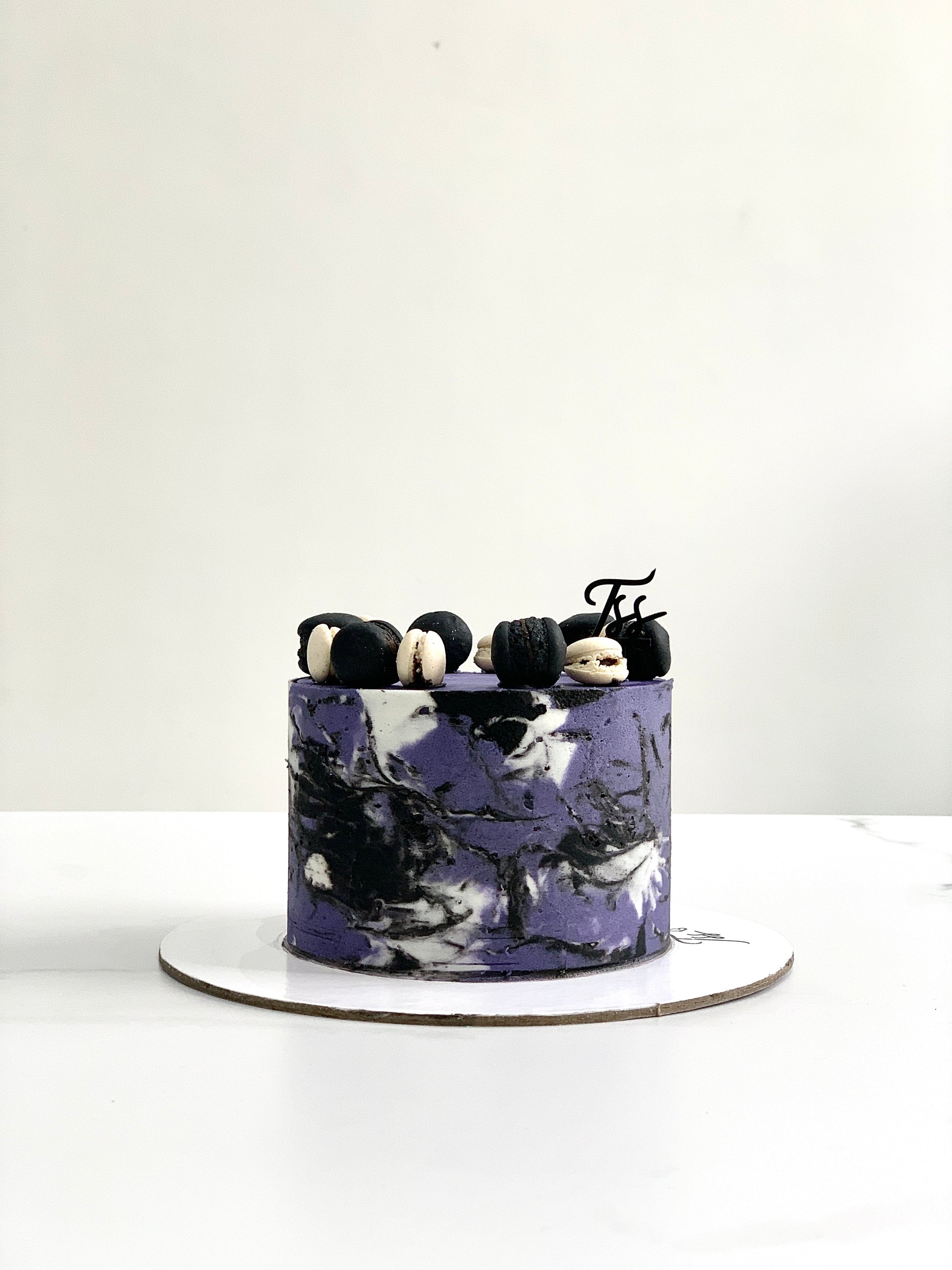 Chocolate layered cake from The Sinful Spoon's Classic Cakes collection, topped with chocolate frosting and decorative sprinkles.