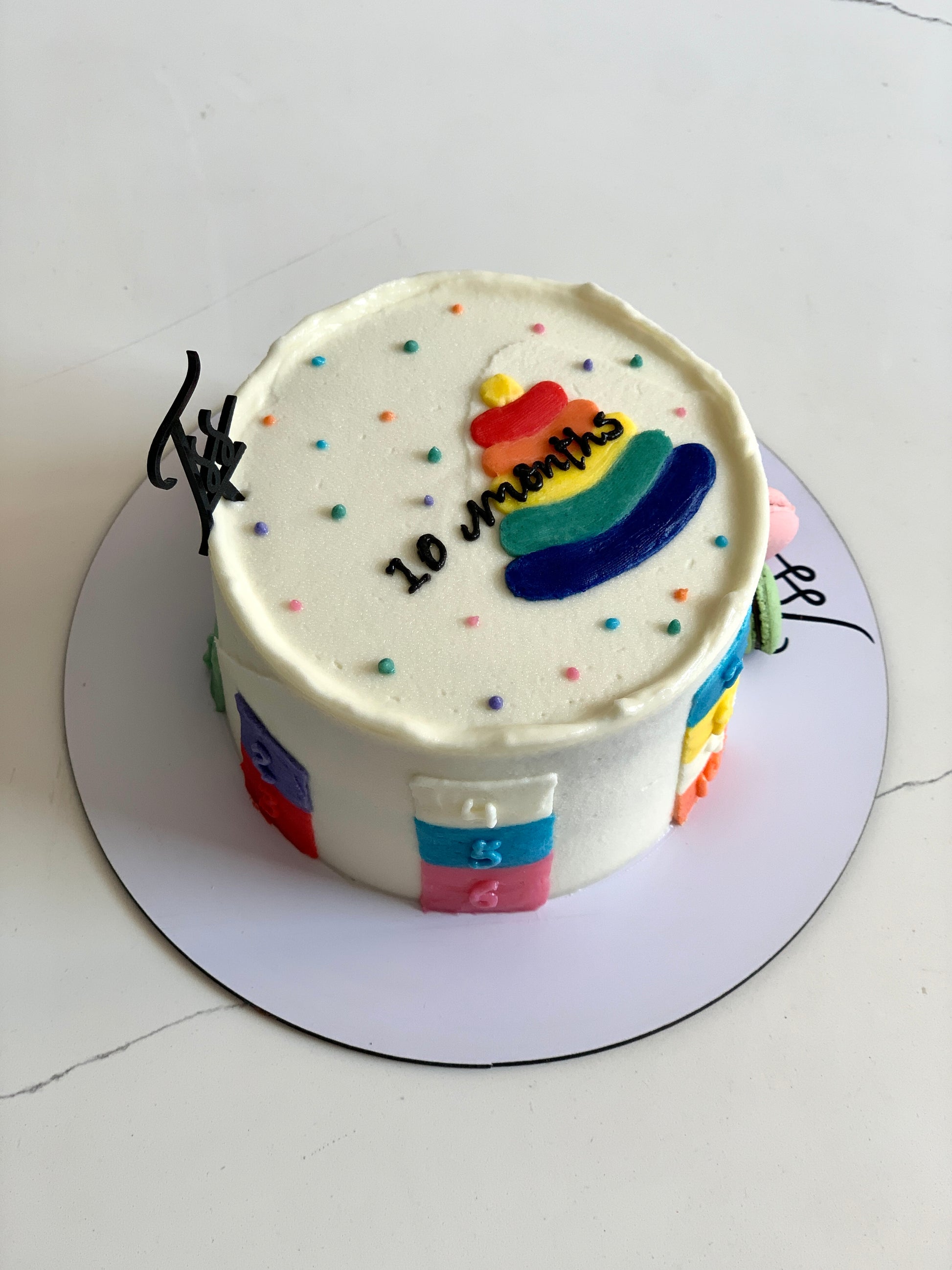 Decorative buttercream illustration cake with colorful floral and swirl designs, handcrafted by The Sinful Spoon.