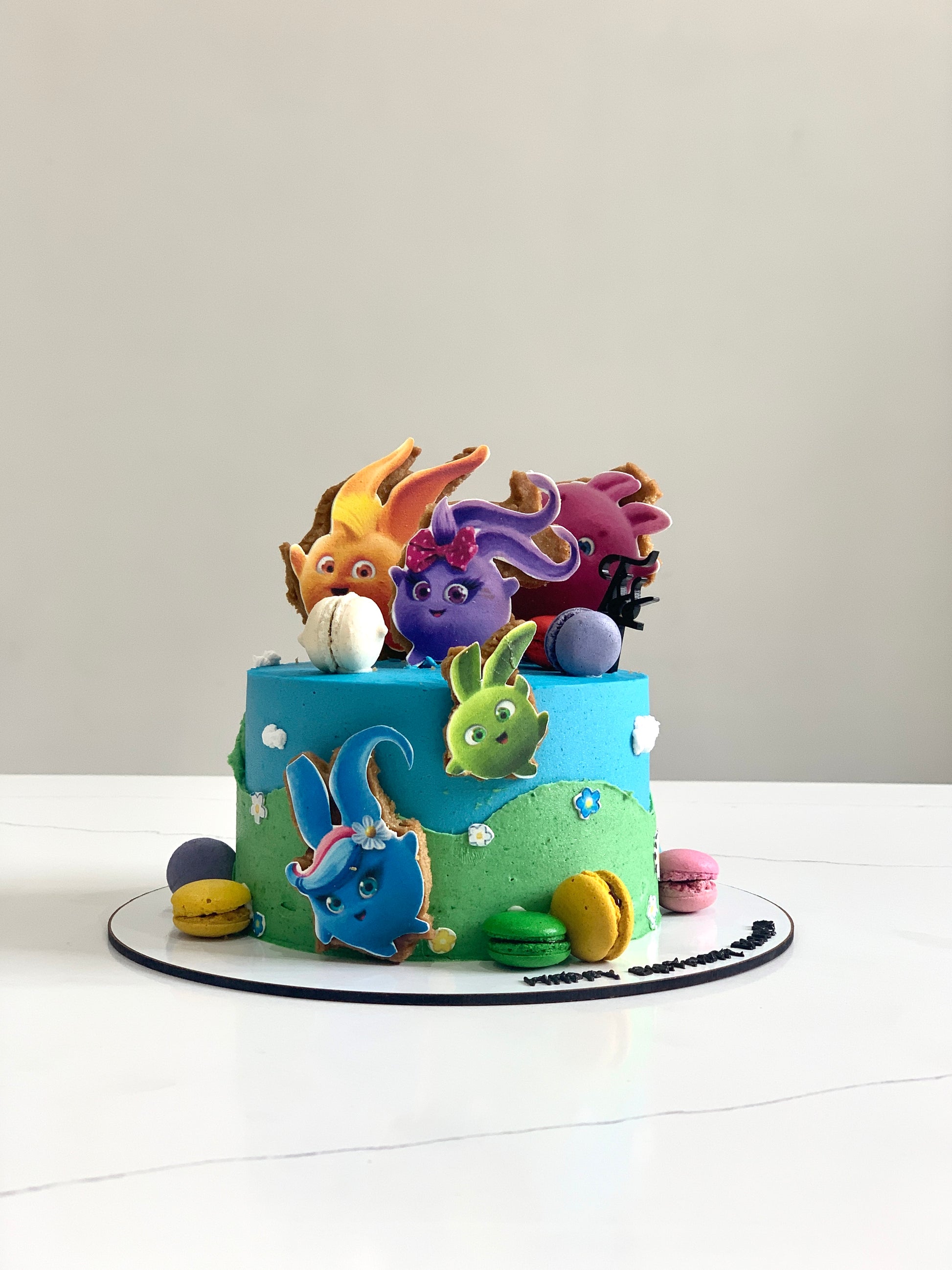 Edible paper cake topper for baby girl by The Sinful Spoon, featuring colorful baby-themed designs on a decorative edible paper.