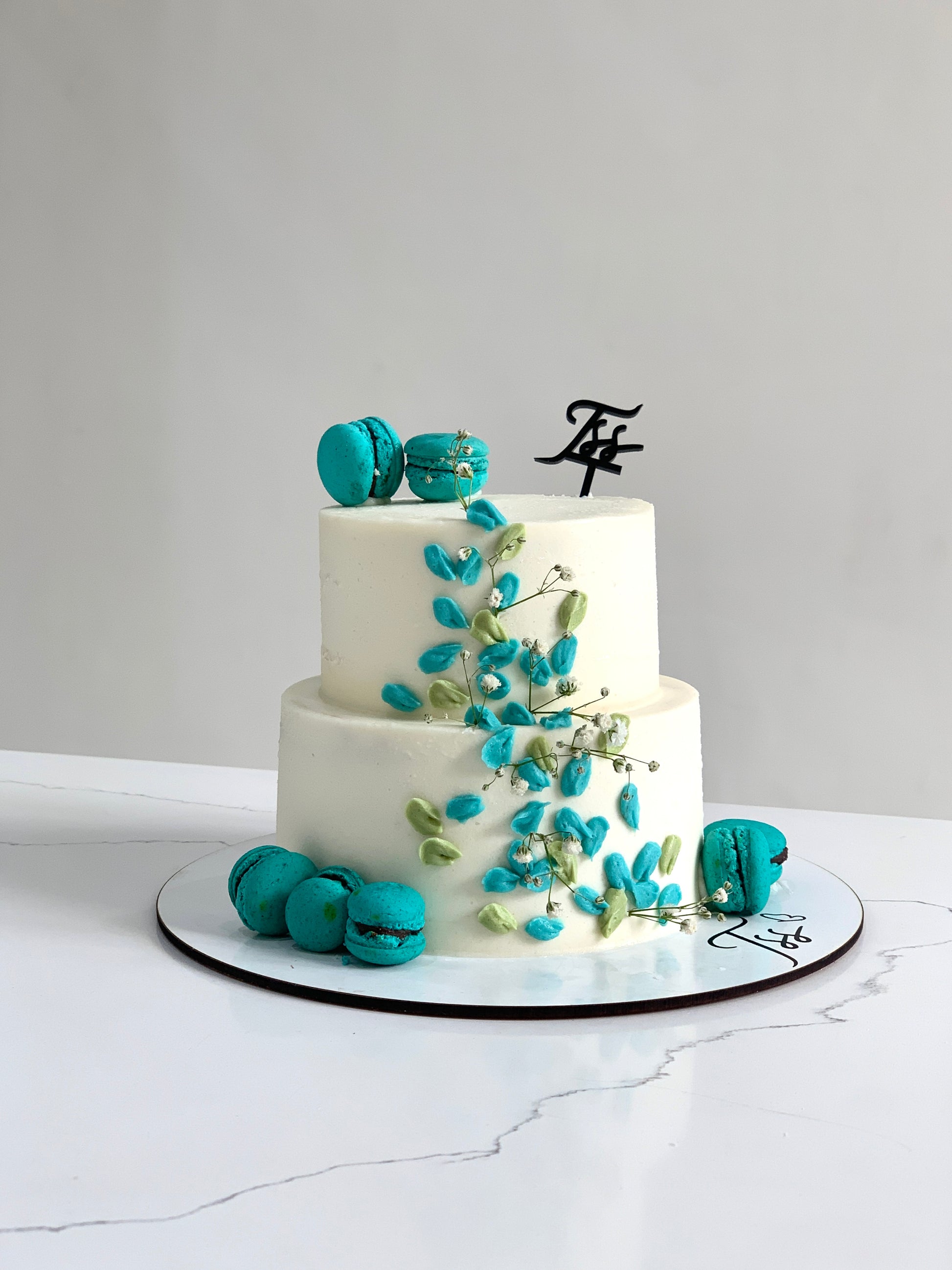Miniature tier cakes from The Sinful Spoon with colorful frosting and intricate decorations, perfect for special occasions.