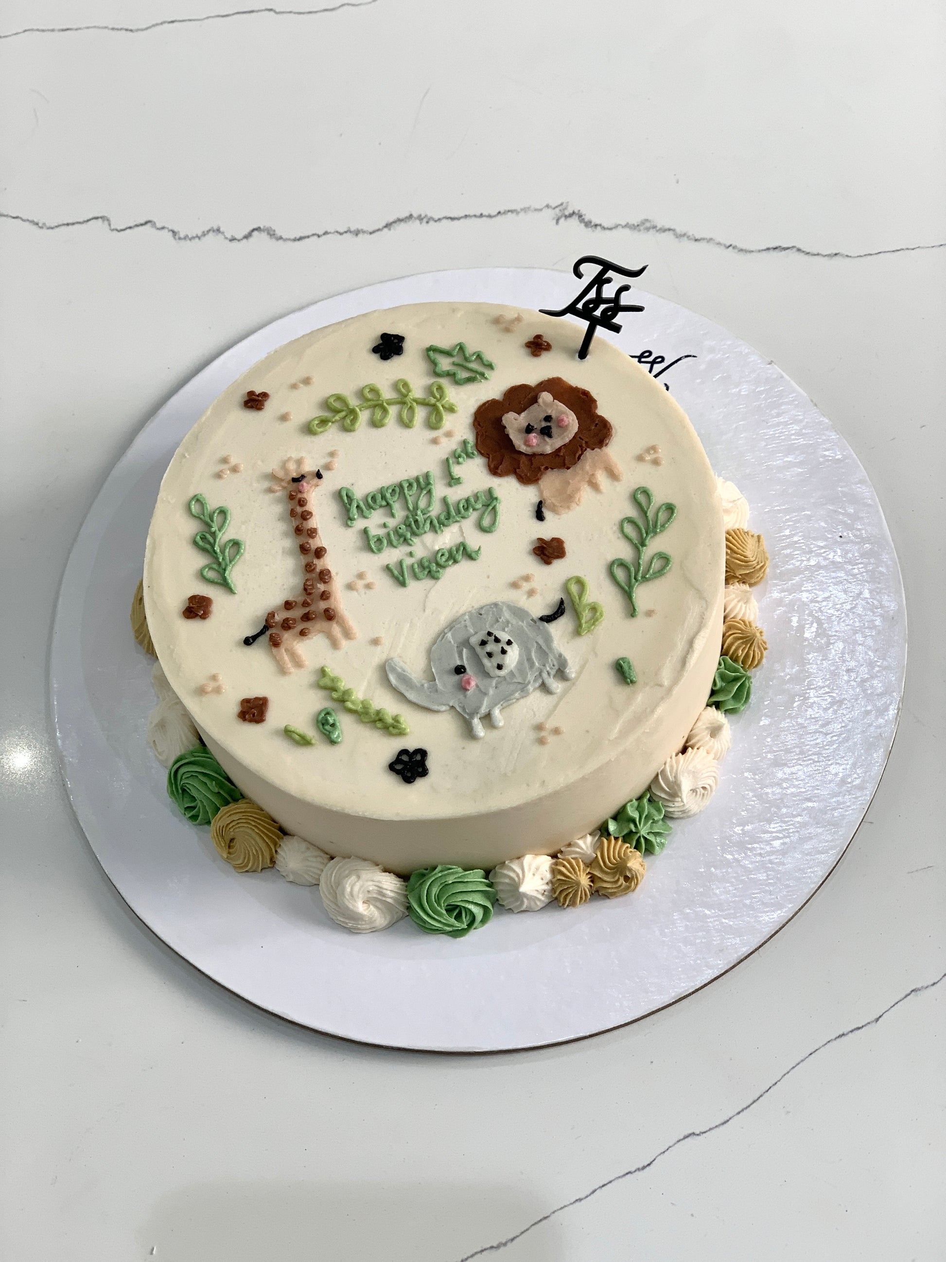 Decorative baby shower cake from The Sinful Spoon, featuring pastel colors and baby-themed designs on a multi-tiered cake.