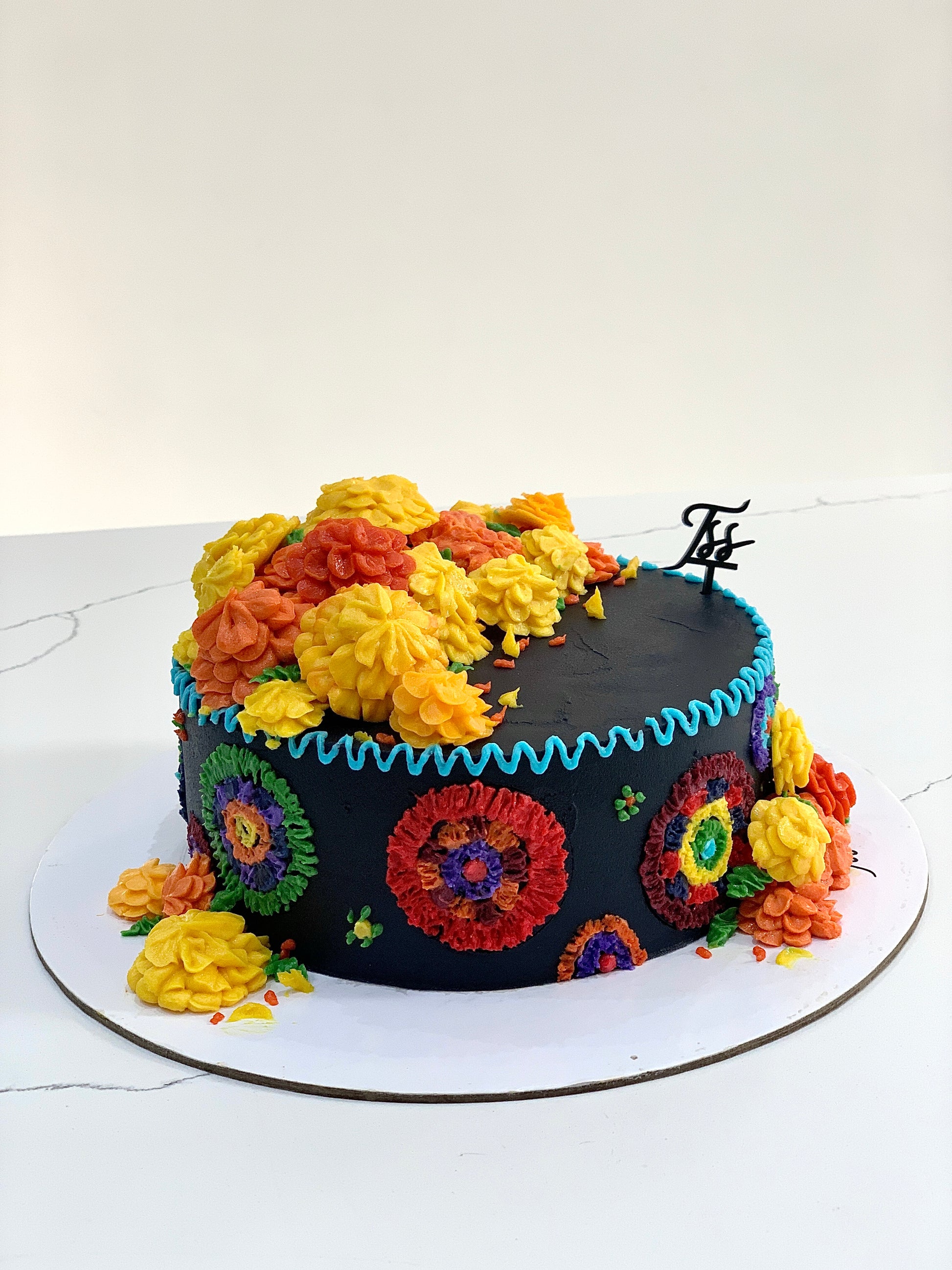 Decorative festive cakes from The Sinful Spoon with colorful icing and holiday-themed designs displayed on a wooden table.