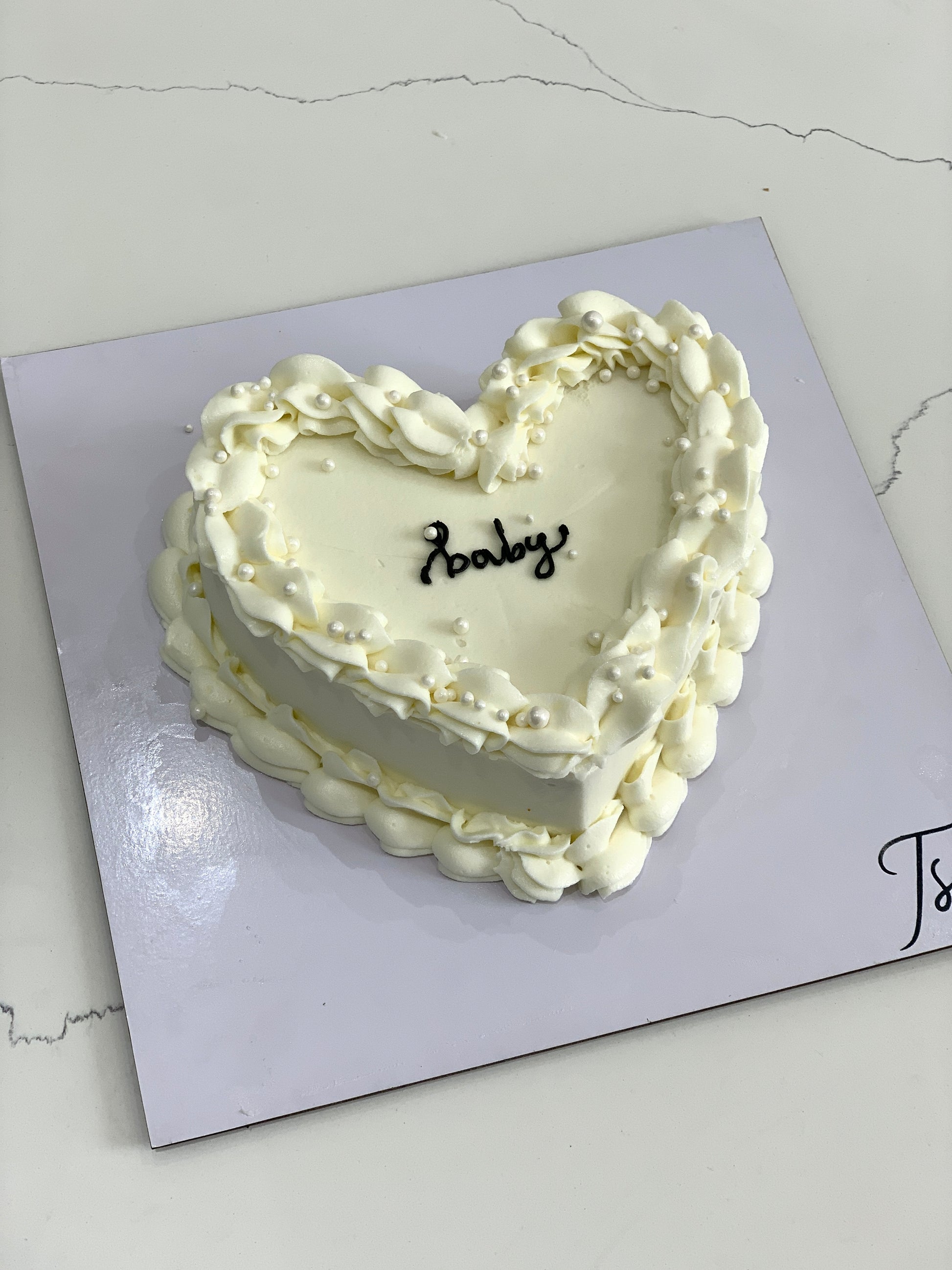 Heart-shaped cakes from The Sinful Spoon, decorated with pink icing and floral accents, perfect for special occasions.